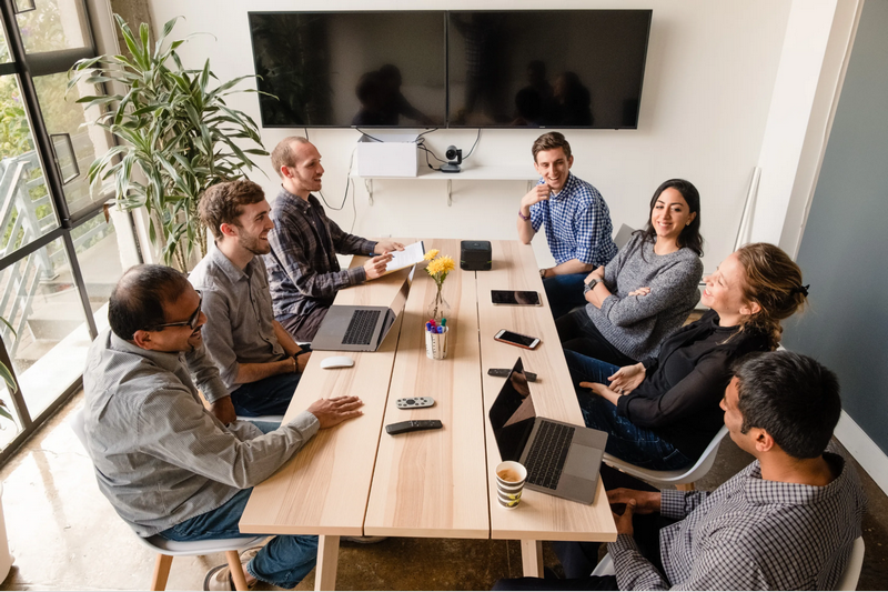 A group of people are having a meeting around a conference table in a modern office.