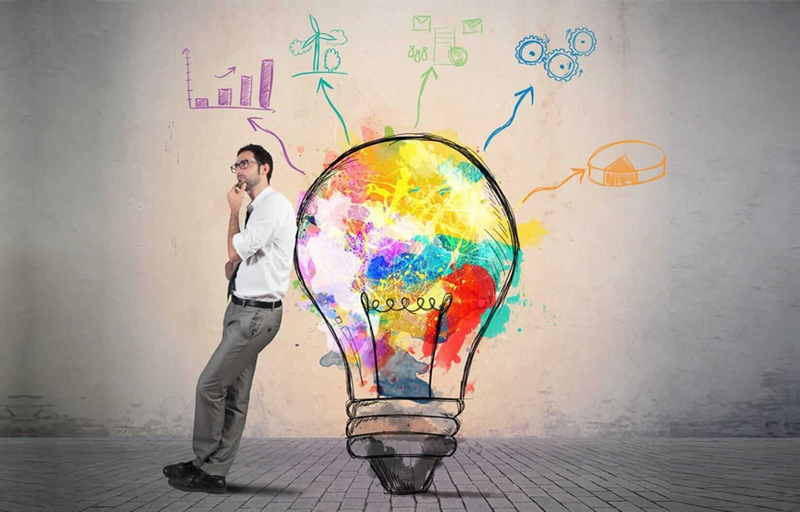 A man leans against a giant, colorful lightbulb with various icons and diagrams emerging from it.